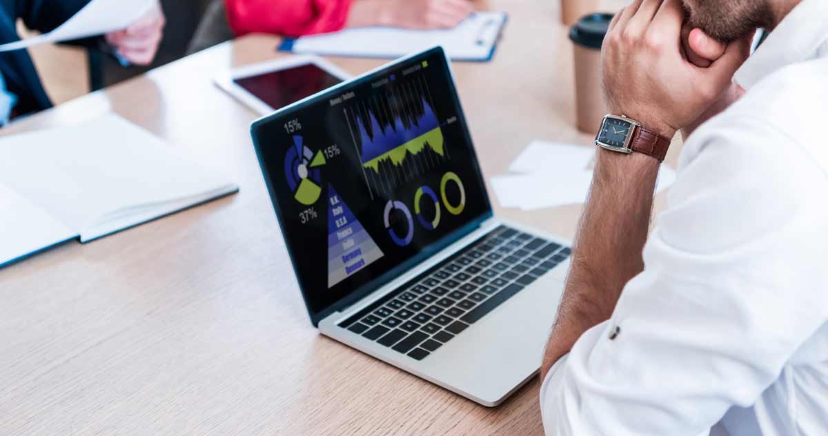 Man looking at stats and data on laptop